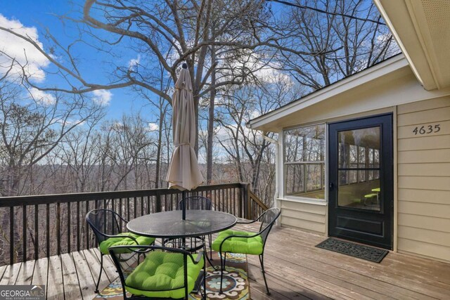 sunroom with wood finished floors, a healthy amount of sunlight, and ceiling fan