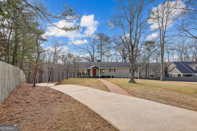 ranch-style house featuring fence, a chimney, and a front lawn