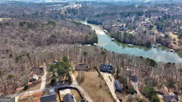 aerial view featuring a wooded view and a water view