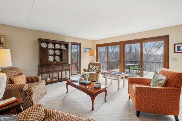 carpeted living area with baseboards and french doors