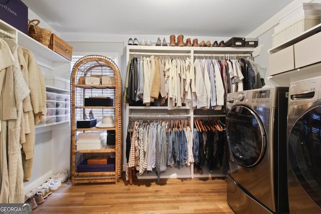 walk in closet with wood finished floors and washer and dryer