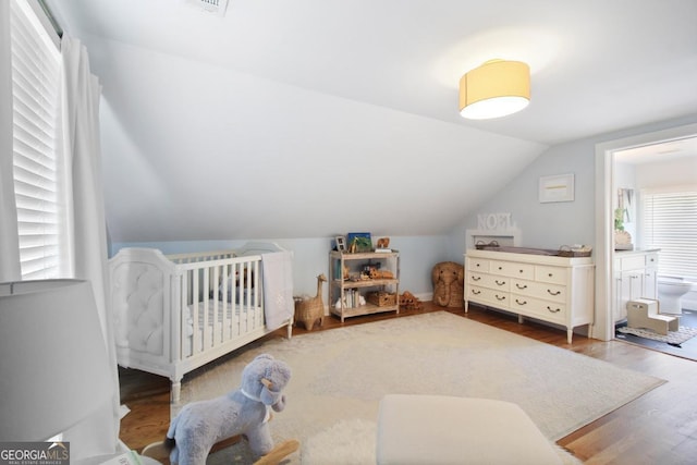 bedroom with lofted ceiling and wood finished floors