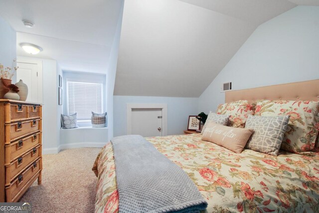 carpeted bedroom with lofted ceiling, baseboards, and visible vents