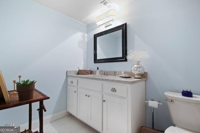 half bathroom with toilet, vanity, visible vents, and baseboards