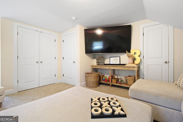 carpeted living area featuring vaulted ceiling and baseboards