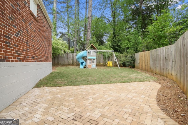 view of patio with a playground and a fenced backyard