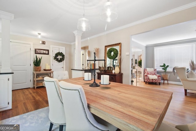 dining room featuring decorative columns, ornamental molding, and dark wood-style flooring