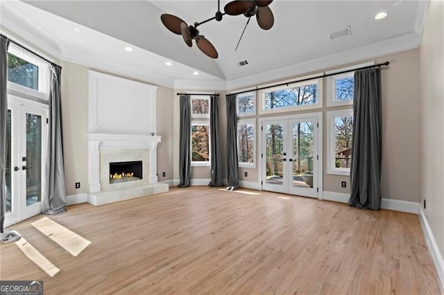 unfurnished living room with plenty of natural light, ornamental molding, and french doors