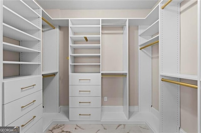 walk in closet featuring marble finish floor