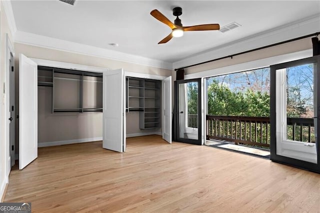 unfurnished bedroom featuring multiple windows, multiple closets, visible vents, and access to exterior