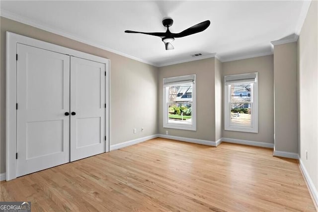 unfurnished bedroom featuring light wood-type flooring, baseboards, visible vents, and ornamental molding