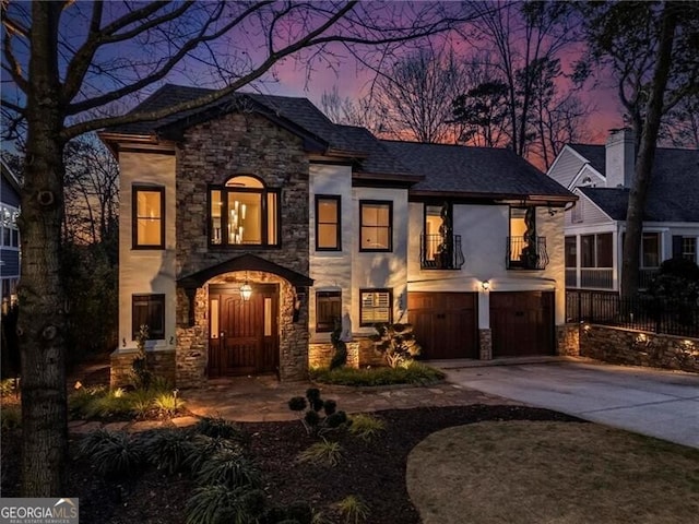 view of front of property featuring driveway, a balcony, and an attached garage