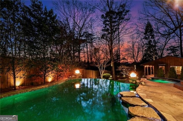 view of pool featuring a fenced in pool, a fenced backyard, a patio, and an in ground hot tub