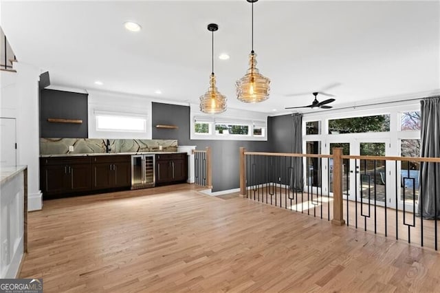 kitchen featuring beverage cooler, pendant lighting, light wood-style flooring, and recessed lighting