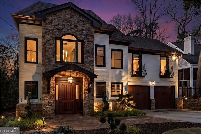 view of front of property with a garage, concrete driveway, a balcony, and stucco siding