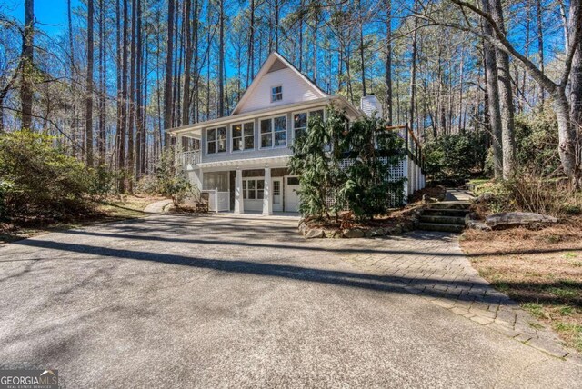 view of front facade featuring driveway and a chimney