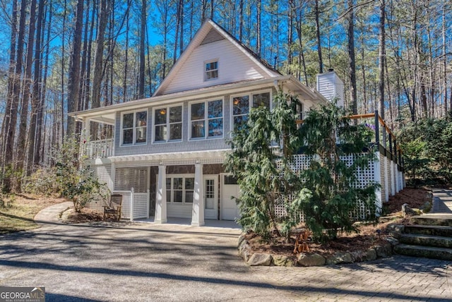 view of front of home with stairs and a chimney