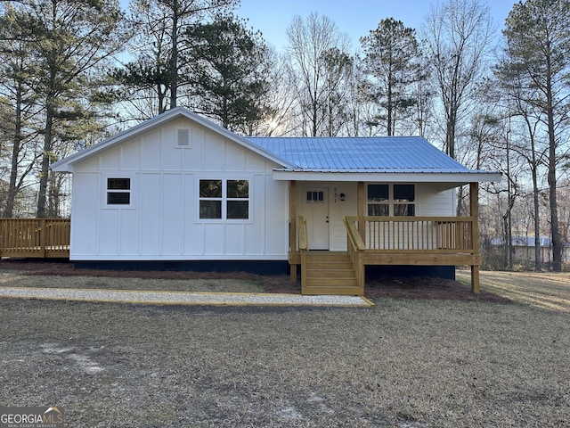 view of front of home featuring board and batten siding, metal roof, and a porch