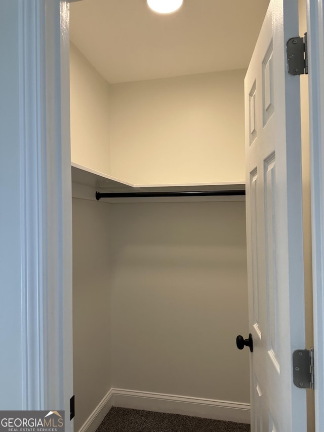 spacious closet featuring dark carpet