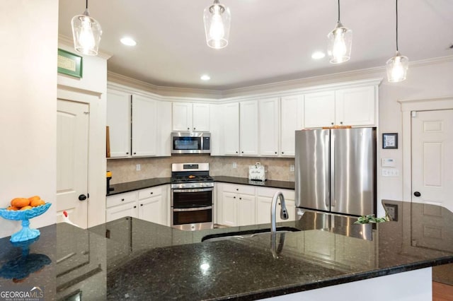 kitchen featuring stainless steel appliances, white cabinetry, a sink, and decorative backsplash