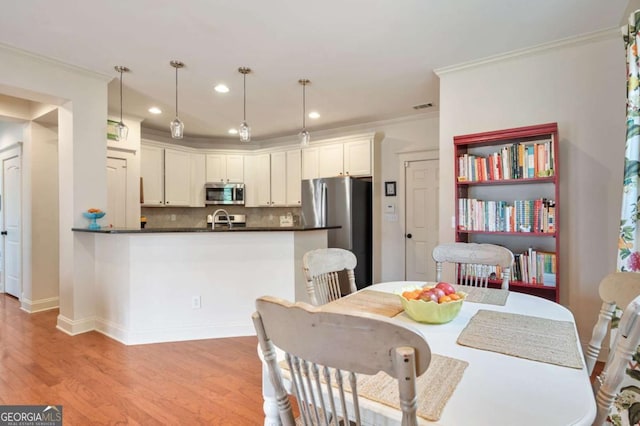 dining space with crown molding, recessed lighting, visible vents, light wood-style flooring, and baseboards