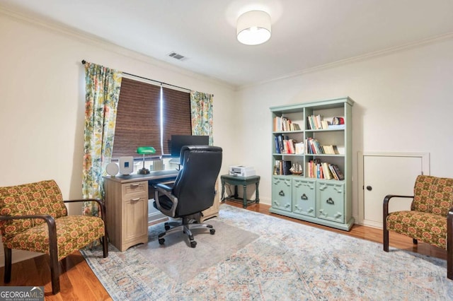 office space with ornamental molding, wood finished floors, and visible vents