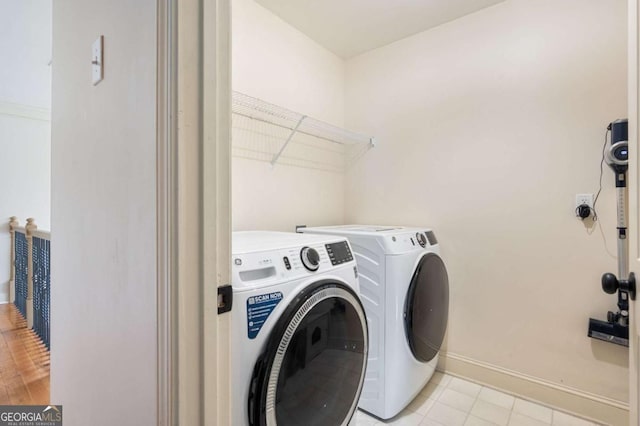 laundry room with laundry area, washer and clothes dryer, and baseboards