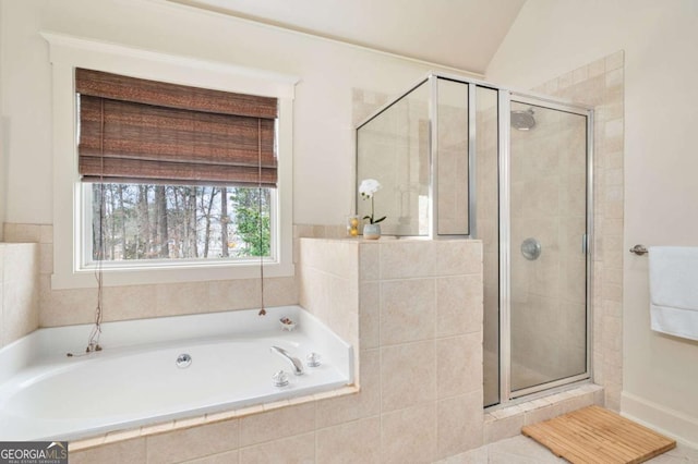 bathroom featuring lofted ceiling, a garden tub, and a shower stall