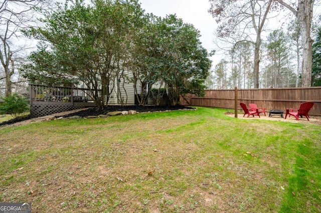 view of yard with an outdoor fire pit, fence, and a wooden deck