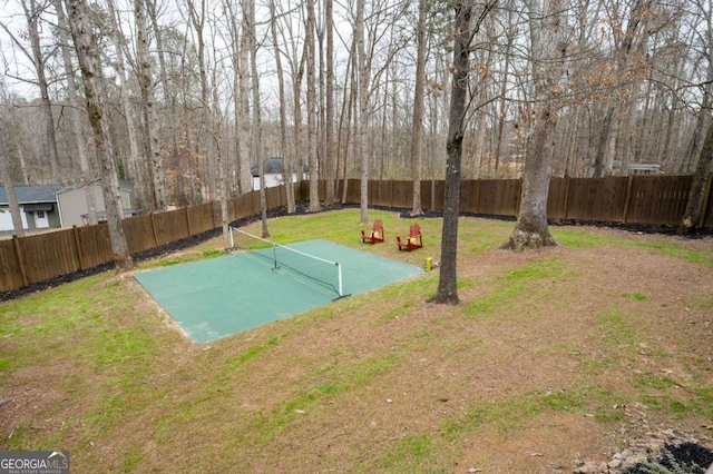 view of sport court featuring a fenced backyard and a yard