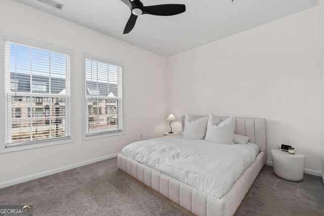 carpeted bedroom featuring a ceiling fan, visible vents, and baseboards