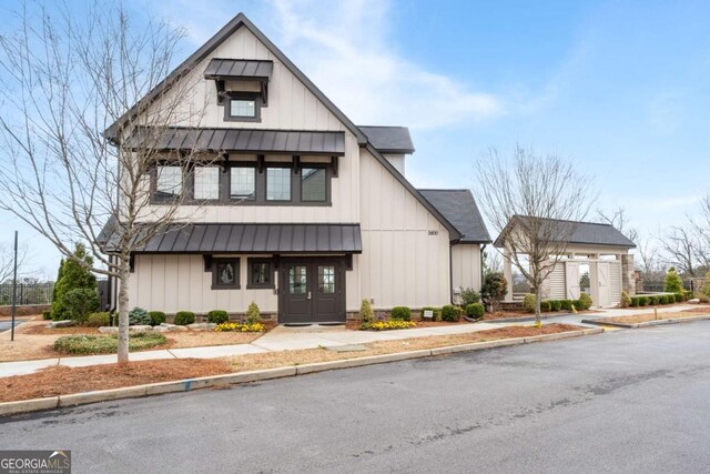 modern farmhouse with board and batten siding, a standing seam roof, and metal roof