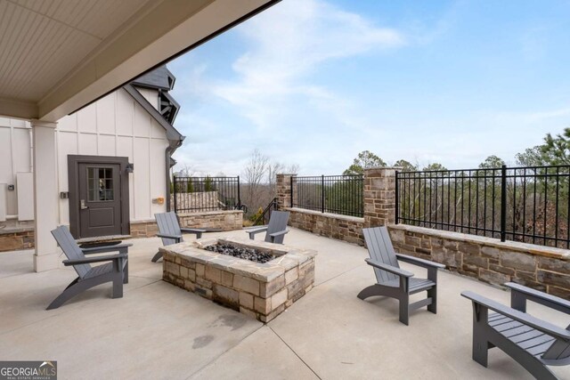 view of patio with an outdoor fire pit and fence