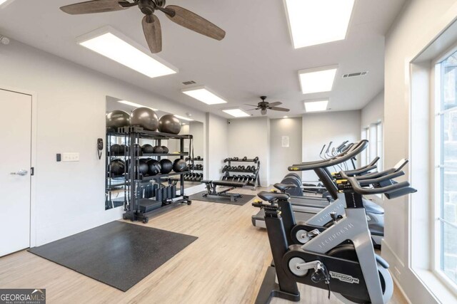 exercise room featuring wood finished floors and visible vents