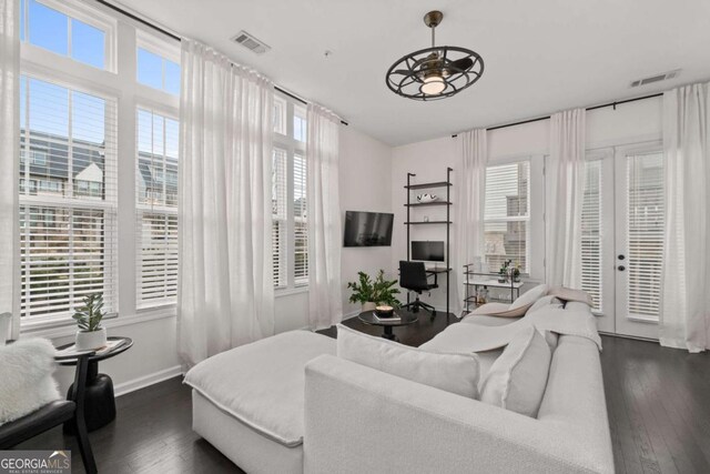 living room featuring a healthy amount of sunlight, dark wood-style floors, and visible vents