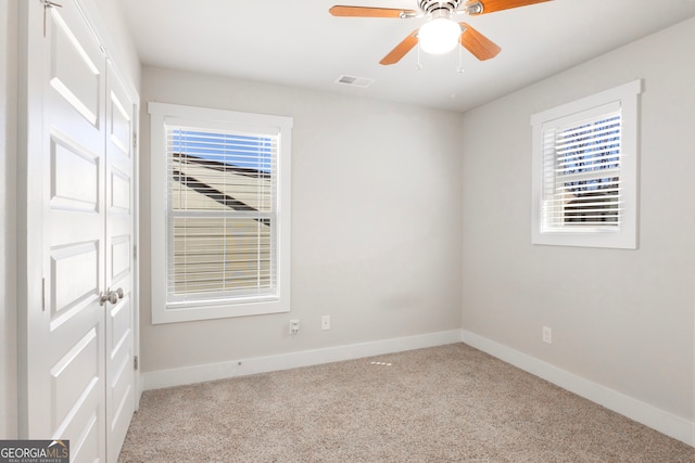 unfurnished room featuring baseboards, visible vents, ceiling fan, and carpet flooring