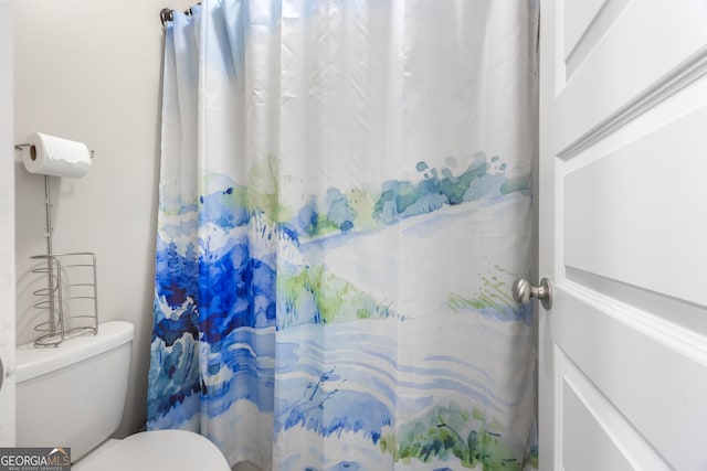 bathroom featuring toilet and a shower with shower curtain