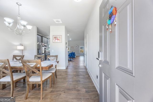 dining space with a notable chandelier, baseboards, and wood finished floors