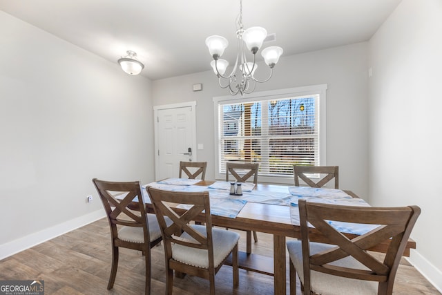 dining room with an inviting chandelier, baseboards, and wood finished floors