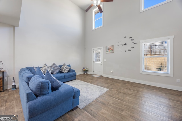 living room featuring a wealth of natural light, baseboards, and wood finished floors