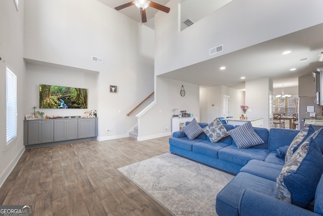 living area with light wood-type flooring, stairway, baseboards, and visible vents