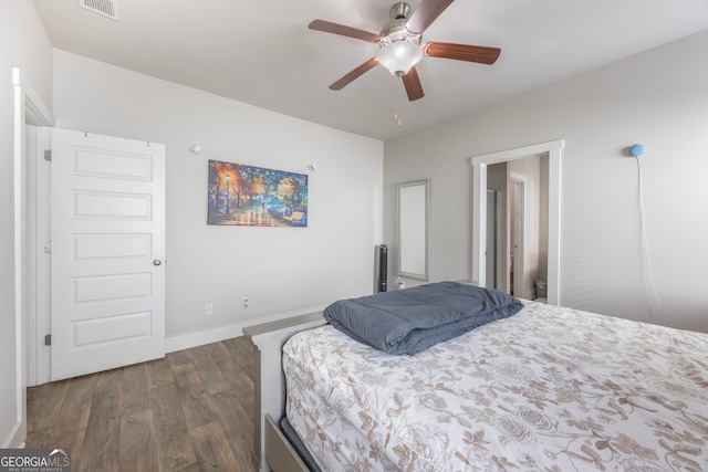 bedroom featuring dark wood-type flooring, a ceiling fan, visible vents, and baseboards