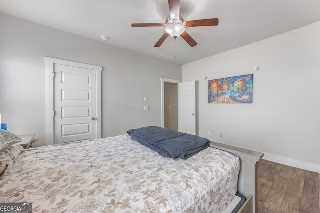 bedroom with wood finished floors, a ceiling fan, and baseboards