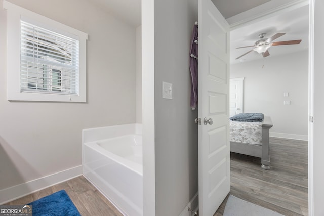 ensuite bathroom featuring baseboards, ceiling fan, wood finished floors, ensuite bathroom, and a garden tub