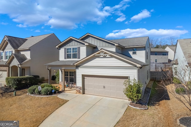 view of front of house with board and batten siding, concrete driveway, covered porch, and fence