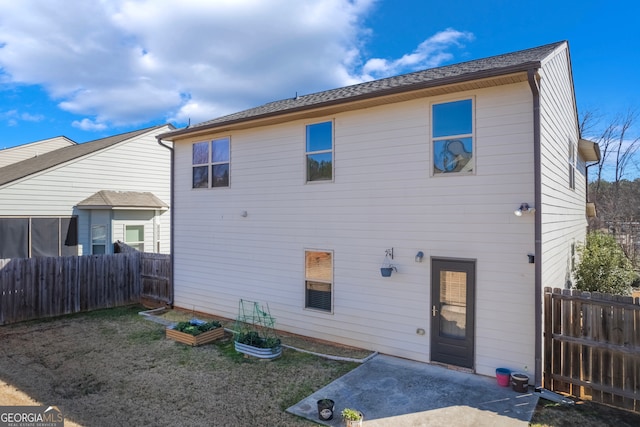 rear view of property with a fenced backyard, a patio area, a vegetable garden, and a lawn