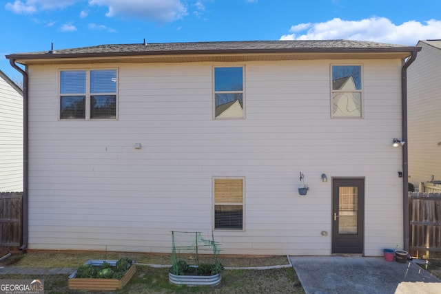 rear view of property with a garden and fence