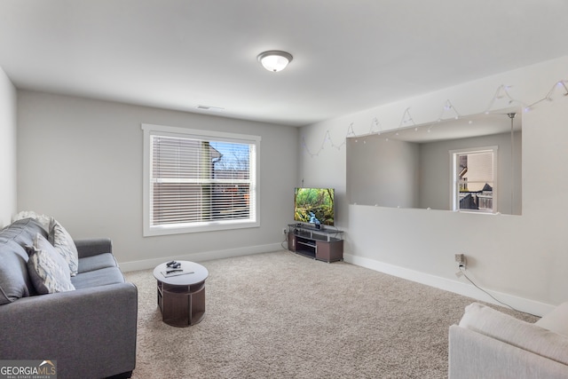 living area featuring carpet floors, visible vents, and baseboards