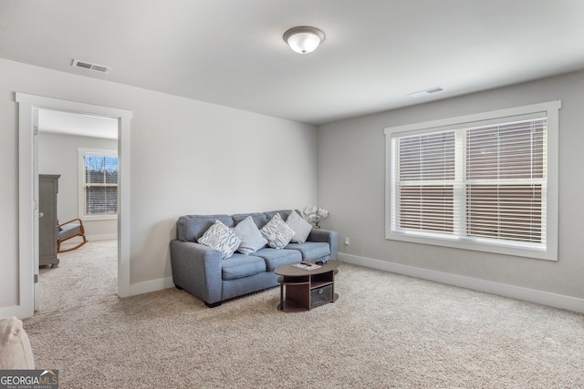 carpeted living area with baseboards and visible vents