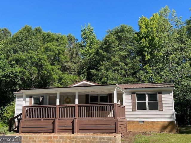 view of front facade featuring covered porch, metal roof, and crawl space